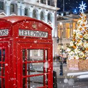 Rote Telefonzelle in London vor einem beleuchtetem Weihnachtsbau