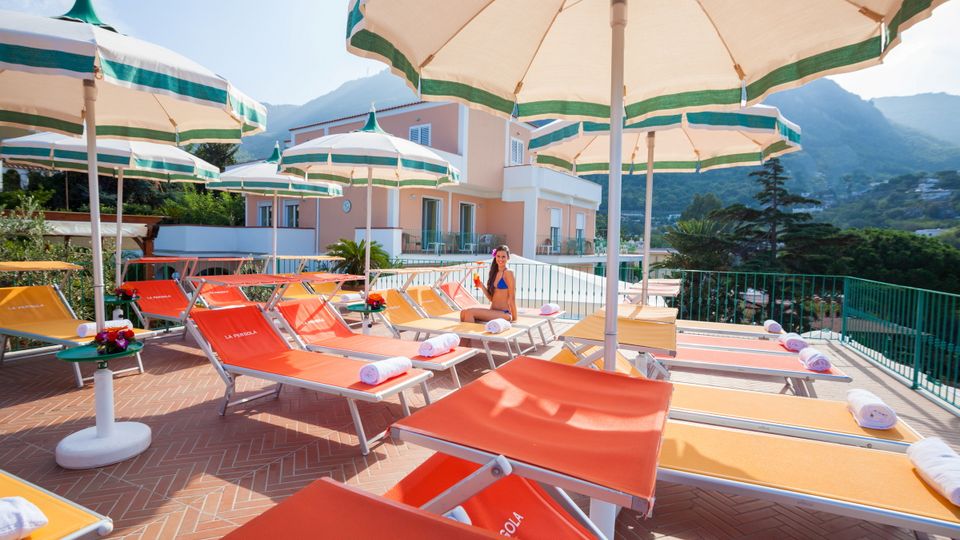 Terrasse der Terme la Pergola mit Sonnenschirm und Liegen bei Ischia, Italien